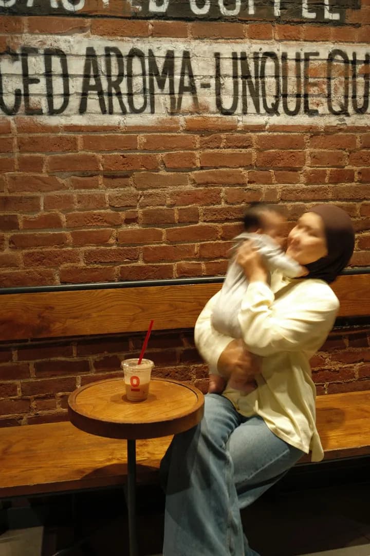 Myrzan's wife holding Medina in a café